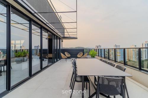 a dining room with a table and chairs on a balcony at RUP - Studios Equipados em Prédio com Piscina in Blumenau
