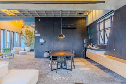 a dining room with a table and a kitchen at RUP - Studios Equipados em Prédio com Piscina in Blumenau