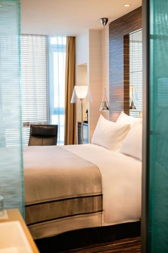 a bedroom with a large white bed and a desk at ROMEO Napoli in Naples