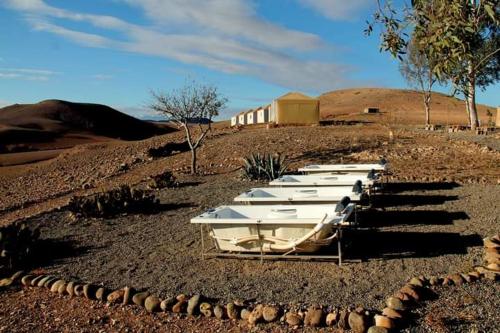 a row of white boats sitting in a field at Ngayan Camp in Marrakech