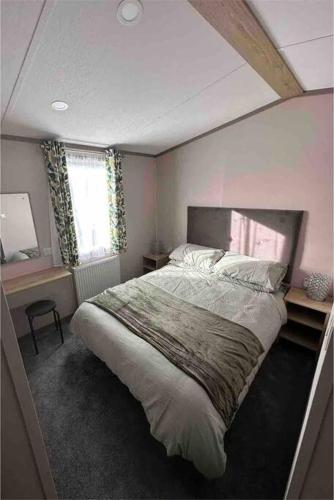 a bedroom with a large bed and a window at BRAND NEW 6 berth holiday home in Selsey