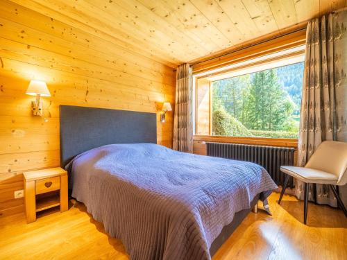 une chambre avec un lit et une grande fenêtre dans l'établissement Appartement 3 chambres avec cheminée, terrasse et parking à La Clusaz - FR-1-437-97, à La Clusaz
