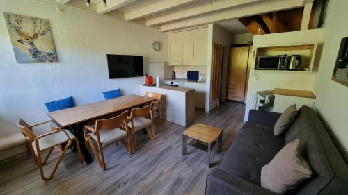 a living room with a table and a couch at Residenza Tga Clo Apartment C119 in Savognin
