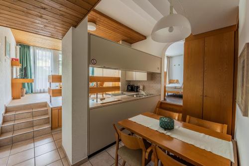 une cuisine et une salle à manger avec une table et une salle à manger dans l'établissement Residenza Tga Clo Apartment 407, à Savognin