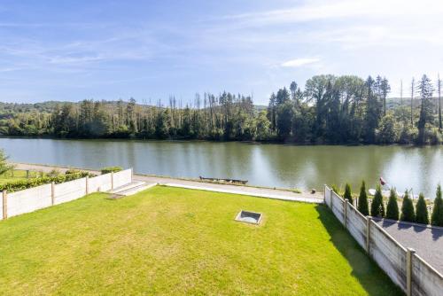 a large backyard with a view of a lake at La Villa Wellness in Hastière-par-delà