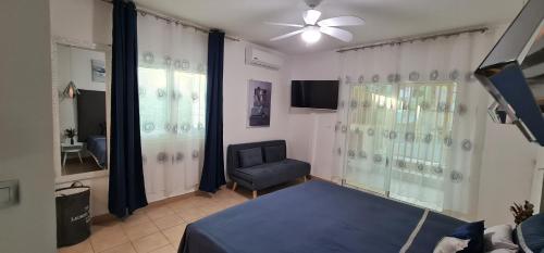 a bedroom with a bed and a chair and a ceiling fan at Le Madina in Pamandzi