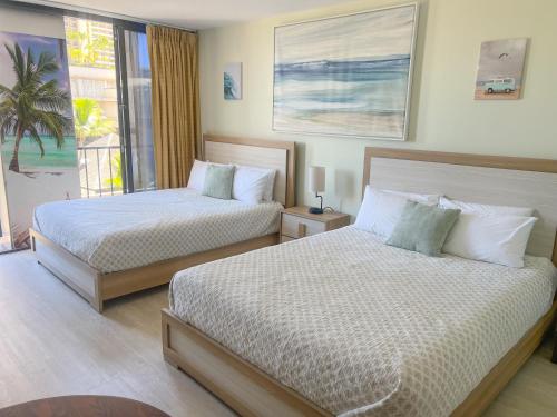2 Betten in einem Schlafzimmer mit Meerblick in der Unterkunft Waikiki Palms in Paradise apts in Honolulu
