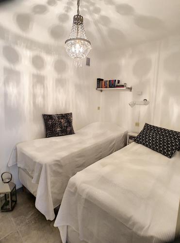 - 2 lits dans une chambre dotée d'un lustre dans l'établissement Front de mer 231L, à Cannes