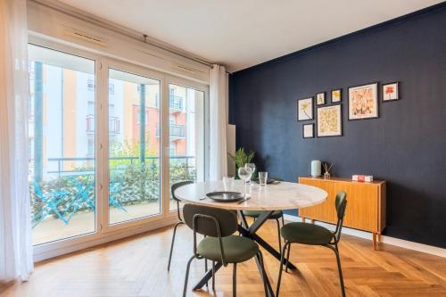 une salle à manger avec une table et des chaises et une fenêtre dans l'établissement Bel appartement bien situé avec balcon et parking, à Lille