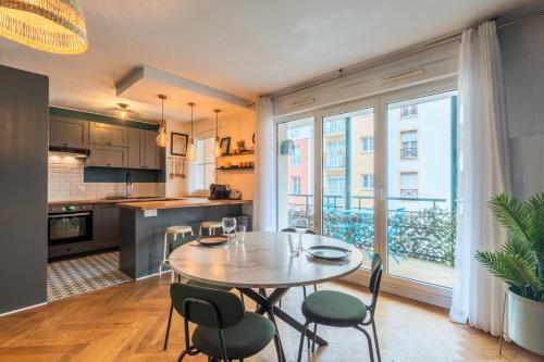 une cuisine et une salle à manger avec une table et des chaises dans l'établissement Bel appartement bien situé avec balcon et parking, à Lille