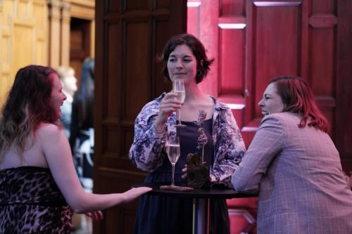 two women standing around a table with a glass of wine at Kimpton Clocktower by IHG in Manchester