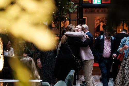 a couple hugging in a crowd of people at Kimpton Clocktower by IHG in Manchester