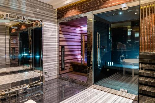 a bathroom with a glass shower and a sink at ROMEO Napoli in Naples