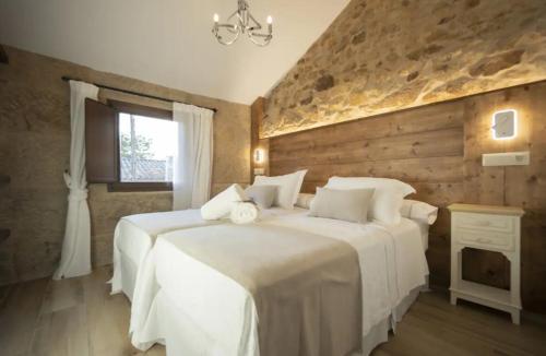 two white beds in a room with wooden walls at O Fogar da Pequena Galia in Caldas de Reis