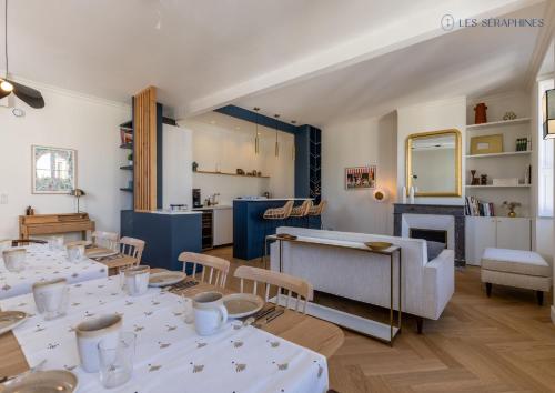 un restaurant avec des tables et des chaises blanches et une cheminée dans l'établissement Les Séraphines - Chambres d'hôtes - Guests house, à Bordeaux