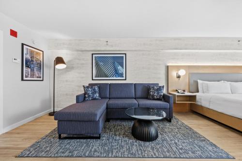 a living room with a couch and a bed at DoubleTree by Hilton New York JFK Airport in Queens