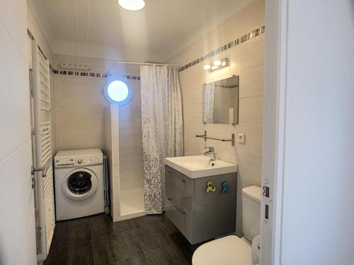 une salle de bain avec un lavabo et une machine à laver dans l'établissement Font de mer, balcon, face plages 266L LEBL, à Cannes