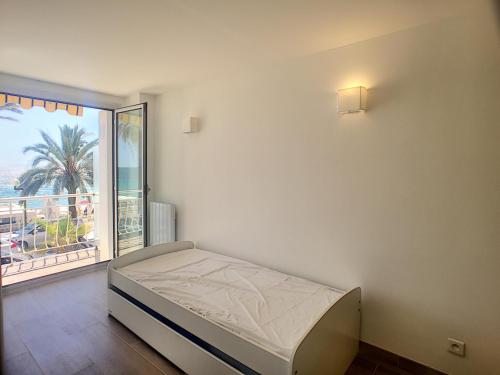 une chambre avec un lit et une grande fenêtre dans l'établissement Font de mer, balcon, face plages 266L LEBL, à Cannes