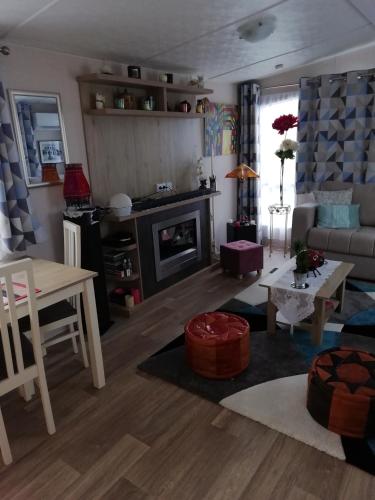 un salon avec un canapé et une table dans l'établissement Mobilhome 41m2 terrasse 15 m2, à Nissan-lez-Enserune