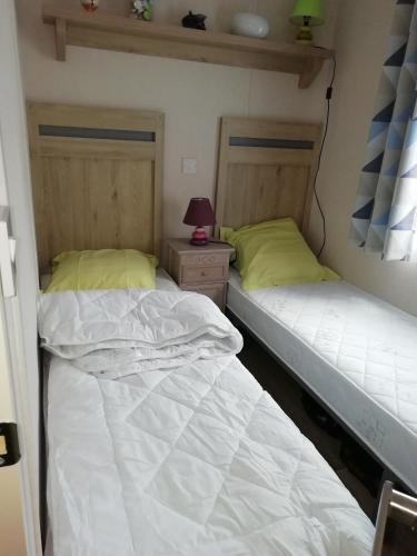 deux lits côte à côte dans une pièce dans l'établissement Mobilhome 41m2 terrasse 15 m2, à Nissan-lez-Enserune