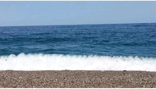 a wave breaking on a beach near the ocean at Focu e Mari in Mascali