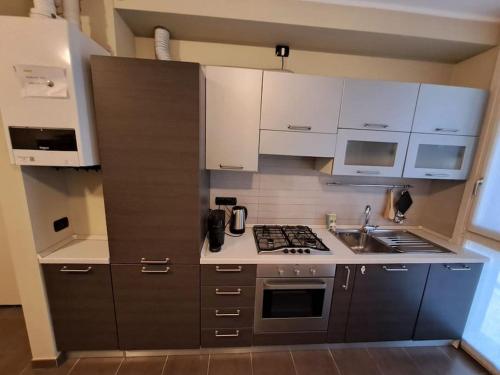 eine Küche mit weißen Schränken und einem Herd mit Backofen in der Unterkunft Casa da Umberto in Parma