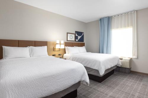 a hotel room with two beds and a window at Staybridge Suites Rogers - Bentonville by IHG in Rogers