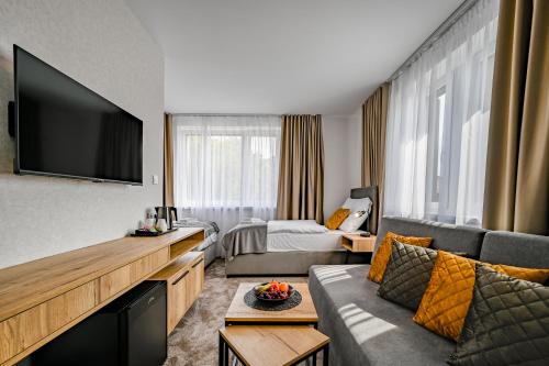 a living room with a couch and a television at PENZIÓN u JAKUBA & REŠTAURÁCIA Bezplatné Parkovanie in Martin