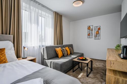 a hotel room with a bed and a couch at PENZIÓN u JAKUBA & REŠTAURÁCIA Bezplatné Parkovanie in Martin