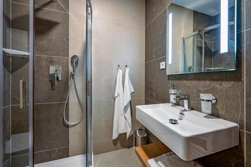 a bathroom with a sink and a shower at PENZIÓN u JAKUBA & REŠTAURÁCIA Bezplatné Parkovanie in Martin
