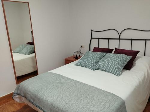 a bedroom with a large bed and a mirror at A casiña de Tuli in Vigo