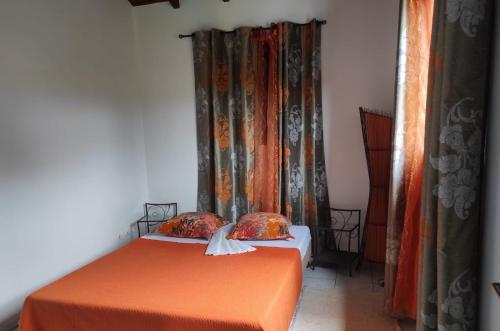 two twin beds in a room with curtains at Espace Nature 97115 in Sainte-Rose