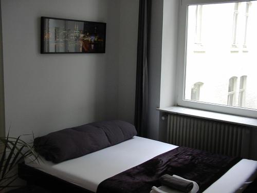 Bett in einem Zimmer mit Fenster in der Unterkunft Ferienwohnung Bankwitz in Köln