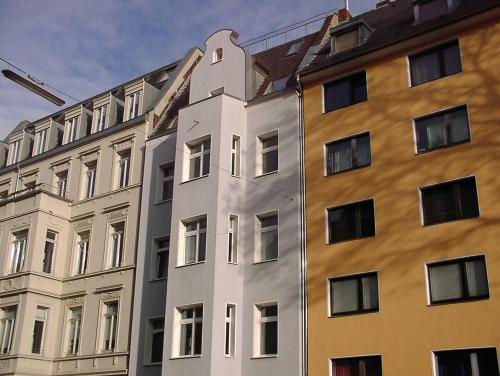 un alto edificio bianco accanto a due edifici di Ferienwohnung Bankwitz a Colonia