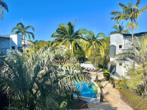 a resort with a swimming pool and palm trees at Bright and Airy 2 Bedroom Apartment in Noosaville