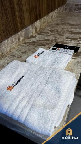 two white towels sitting on top of a table at Hotel Planaltina in Planaltina