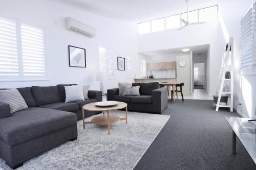 a living room with a couch and a table at Bright and Airy 2 Bedroom Apartment in Noosaville