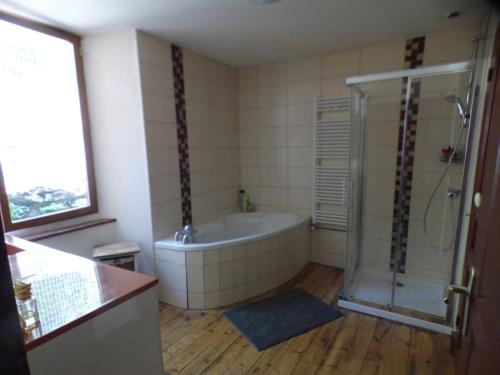 a bathroom with a bath tub and a shower at Maison familiale pour 8 in Saint-Aventin