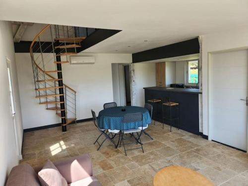 un salon avec une table bleue et une cuisine dans l'établissement Gîte l'atelier, à Mensignac