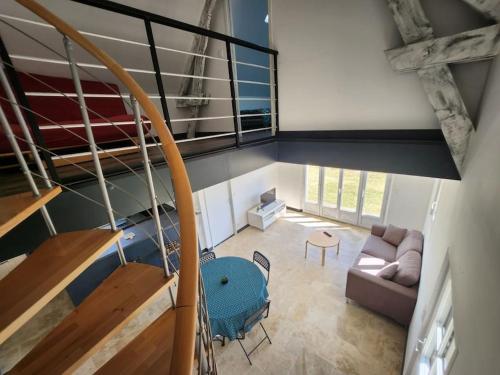 une vue de tête sur un salon avec un escalier dans l'établissement Gîte l'atelier, à Mensignac