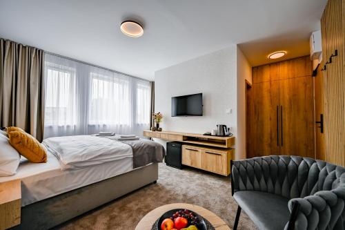 a bedroom with a bed and a chair and a television at PENZIÓN u JAKUBA & REŠTAURÁCIA Bezplatné Parkovanie in Martin