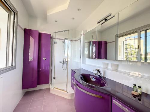 La salle de bains violette est pourvue d'un lavabo et d'une douche. dans l'établissement Vaste 4p Bord de mer, terrasse, piscine 263L DILLI, à Cannes