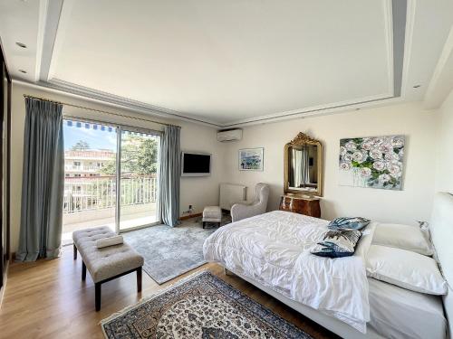 une chambre avec un lit et une grande fenêtre dans l'établissement Vaste 4p Bord de mer, terrasse, piscine 263L DILLI, à Cannes