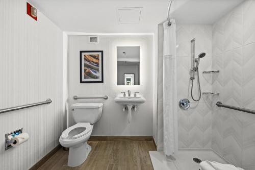 a bathroom with a toilet and a sink and a shower at DoubleTree by Hilton New York JFK Airport in Queens