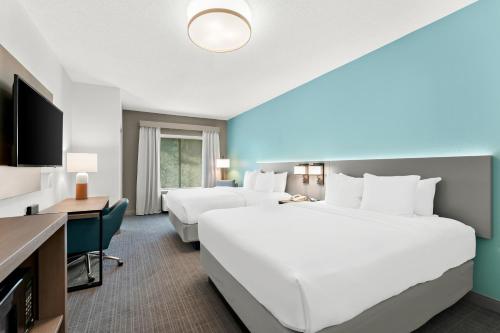 a hotel room with two beds and a desk at Comfort Inn & Suites Tunkhannock in Tunkhannock