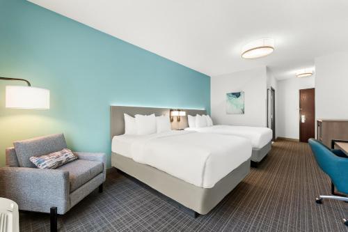 a hotel room with a large bed and a chair at Comfort Inn & Suites Tunkhannock in Tunkhannock
