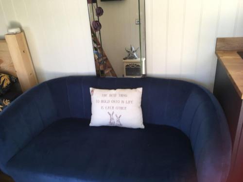 a blue couch with a white pillow on it at Shepherds Haven in Draycott in the Moors