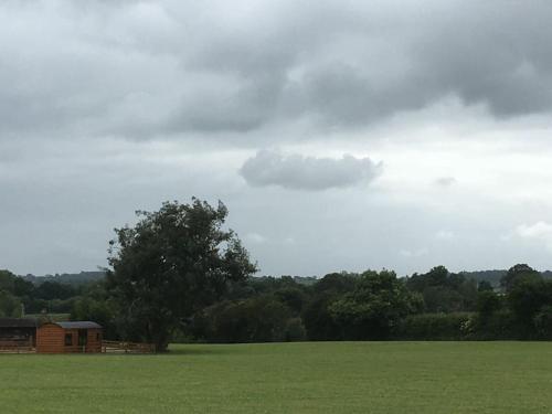 a large green field with a building in the background at Shepherds Haven in Draycott in the Moors