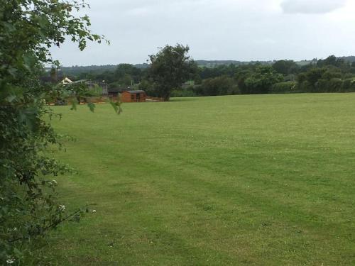 a large green field with a house in the distance at Shepherds Haven in Draycott in the Moors