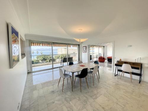 une salle à manger avec une table et des chaises dans l'établissement Superbe 4 pièces vue mer 320L DEL, à Cannes